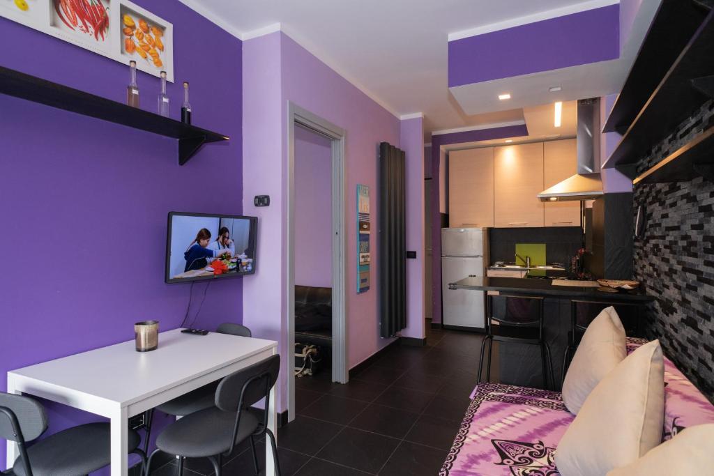 ein Wohnzimmer mit lilafarbenen Wänden und einem weißen Tisch in der Unterkunft Sonia Flat - Hillside Retreat in Finale Ligure