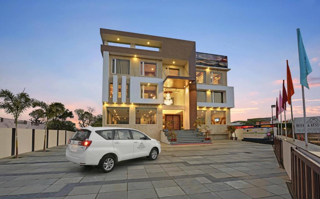 a white car parked in front of a building at Hotel The Rising in Udaipur