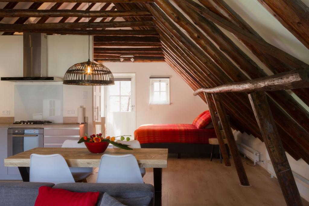 a kitchen and a living room with a table and chairs at Appartement Badnieuweschans in Bad-Nieuweschans
