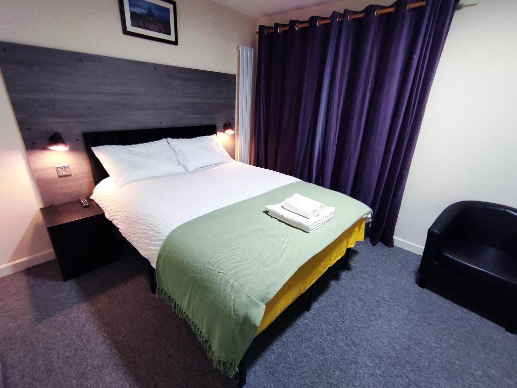 een hotelkamer met een bed en een stoel bij Osney Hazel Studio - Self Contained Studio Flat in Oxford