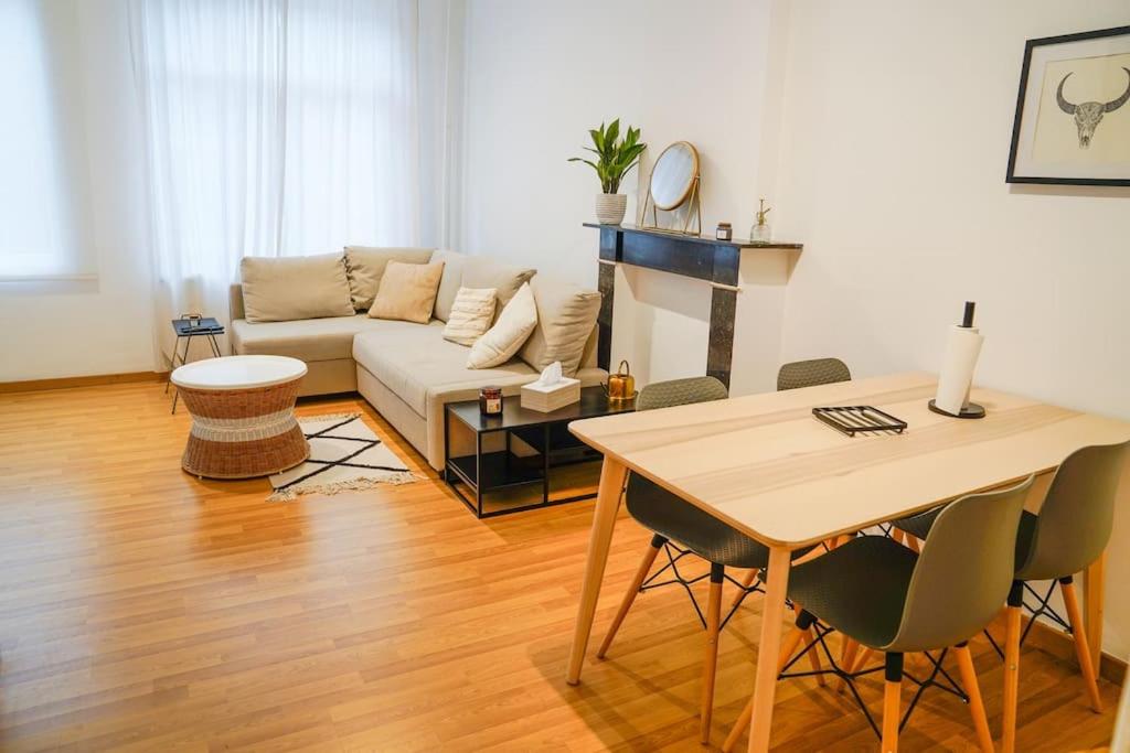 迪南的住宿－Appartement tout confort au centre ville de DINANT，客厅配有沙发和桌子
