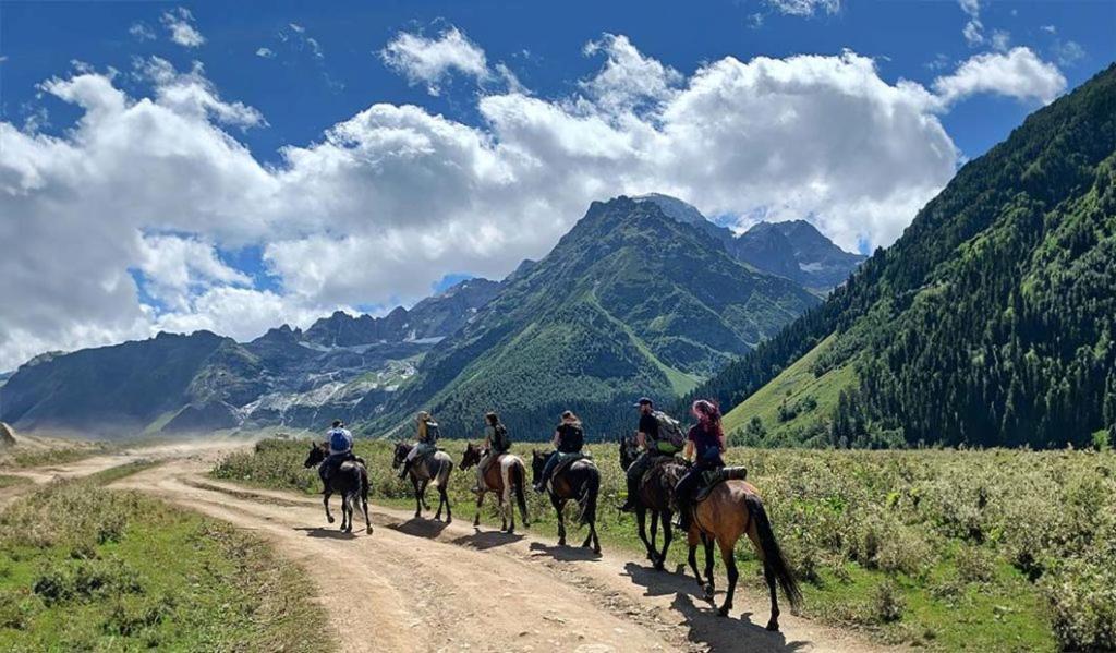 un groupe de personnes à cheval sur un chemin de terre dans l'établissement кайынды, à Acha-Kayyngdy