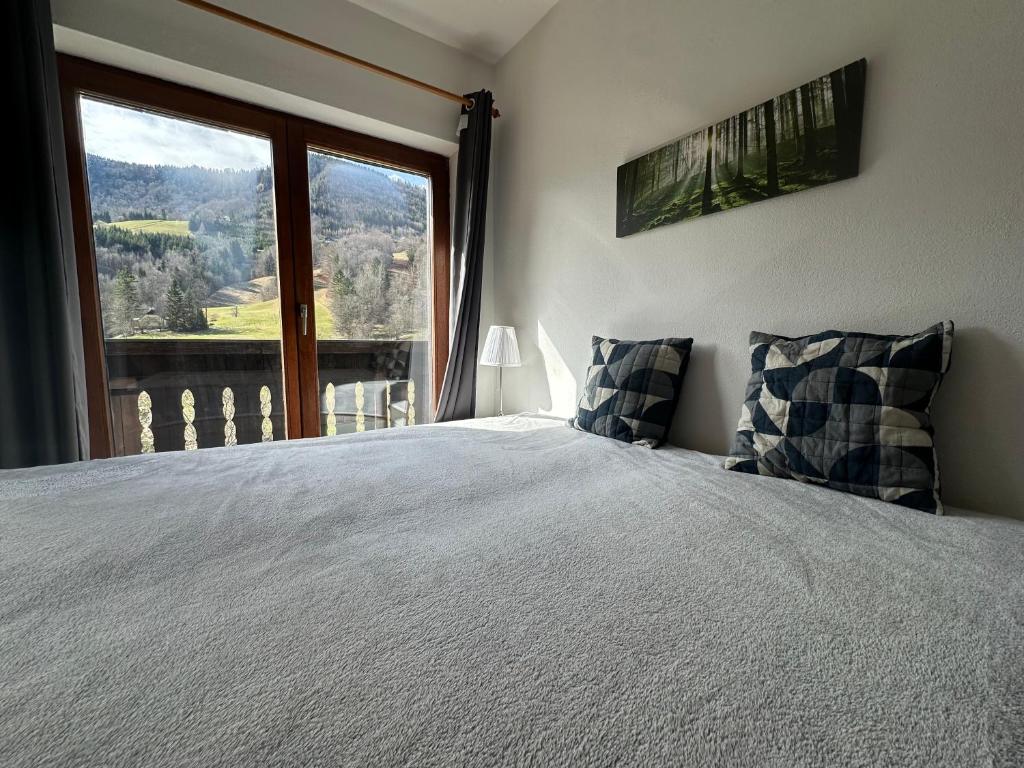 a bedroom with a bed and a large window at Piano Annaberg Apartments in Annaberg