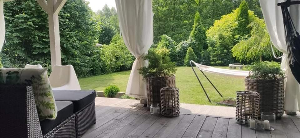 a patio with a couch and a view of a yard at Dom Skandynawski Sen in Wałcz