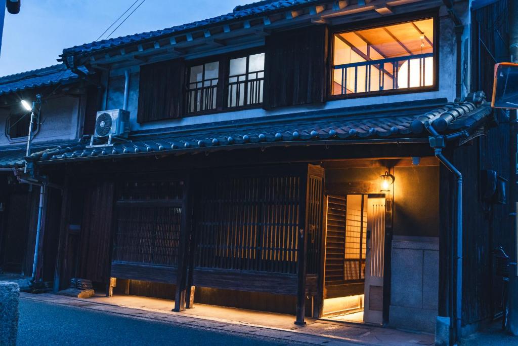 un vieux bâtiment avec une fenêtre sur le côté de celui-ci dans l'établissement Johns House じょんのやど, à Himeji