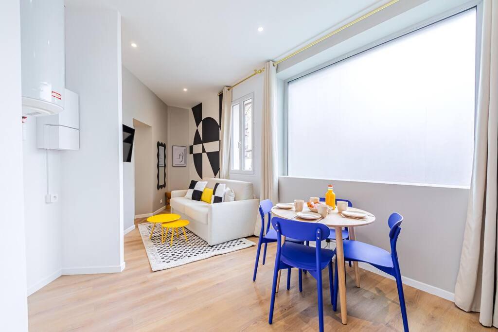 une salle à manger avec une table et des chaises bleues dans l'établissement Appartement cosy proche de la capitale, à Bagnolet