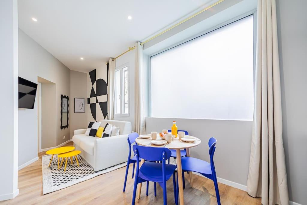 un salon avec une table, des chaises et un canapé dans l'établissement Appartement cosy proche de la capitale, à Bagnolet