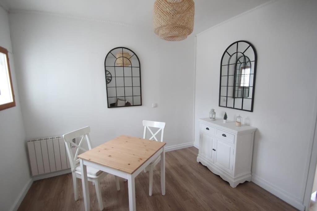 a dining room with white walls and a table and chairs at Le Cosy au cœur de Brétigny in Brétigny-sur-Orge