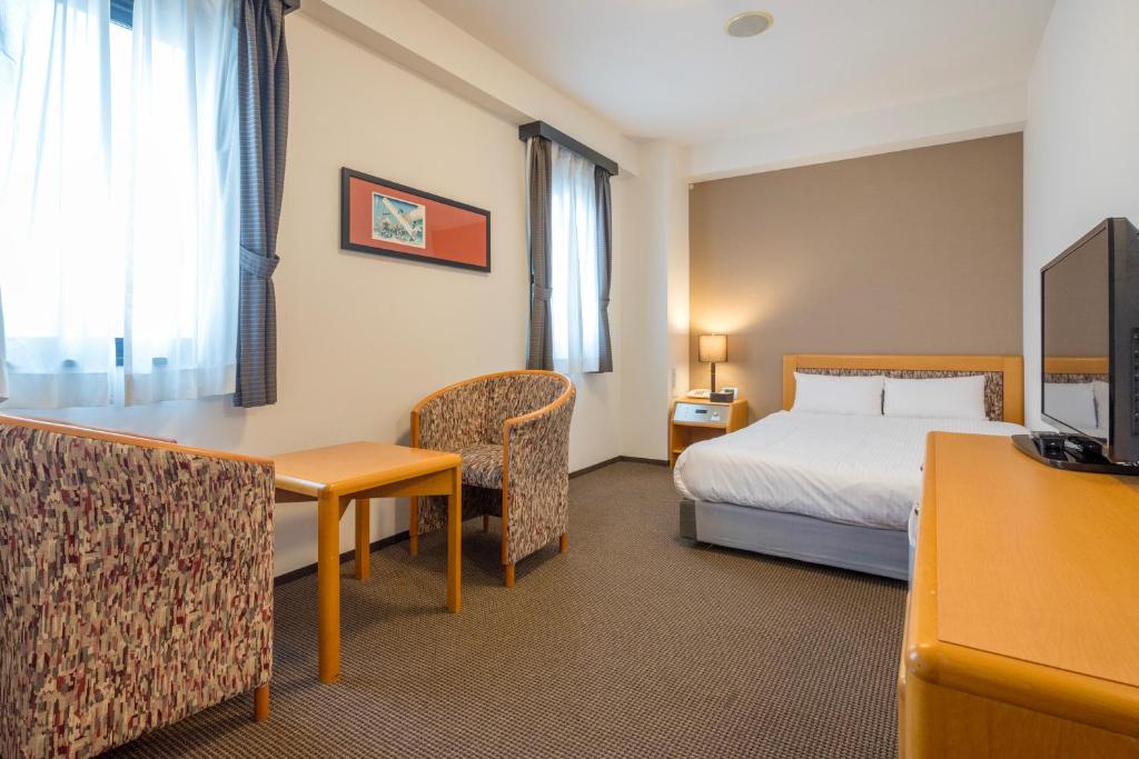 ein Hotelzimmer mit einem Bett und einem Schreibtisch in der Unterkunft Hotel JIN Morioka Ekimae in Morioka