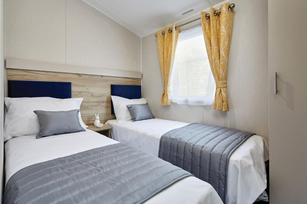a bedroom with two beds and a window at Home Farm Park - Static Caravans in Burgh le Marsh