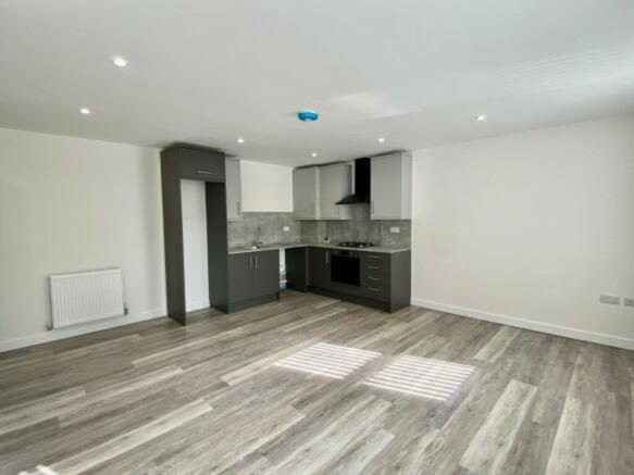 um quarto vazio com uma cozinha e um piso de madeira em BELMAYNE APARTMENTS em Dublin