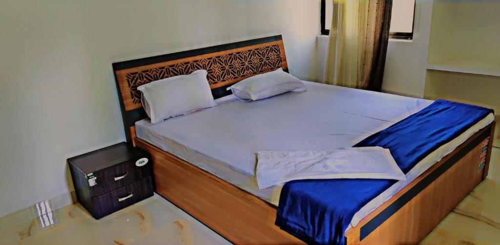 a bedroom with a large bed with a wooden headboard at Glamour Palace in Gaya