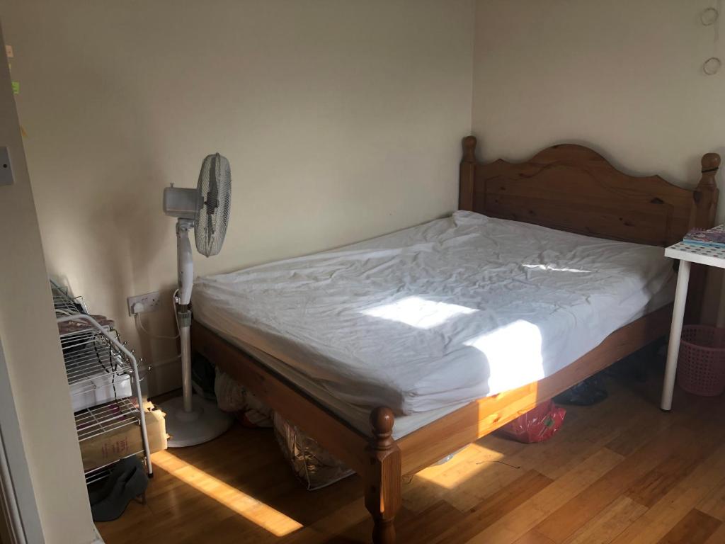 a bedroom with a bed and a fan at London Homestay with big double room in London