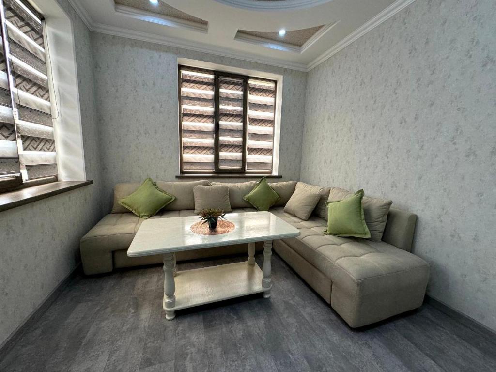 een woonkamer met een bank en een tafel bij OS Rill in Samarkand