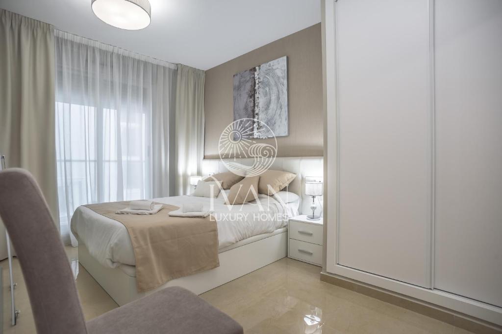 a bedroom with a bed with a chair and a mirror at Casa Bravo Ivan Luxury Homes 1ªPta Sur 1ªLínea in Castellón de la Plana