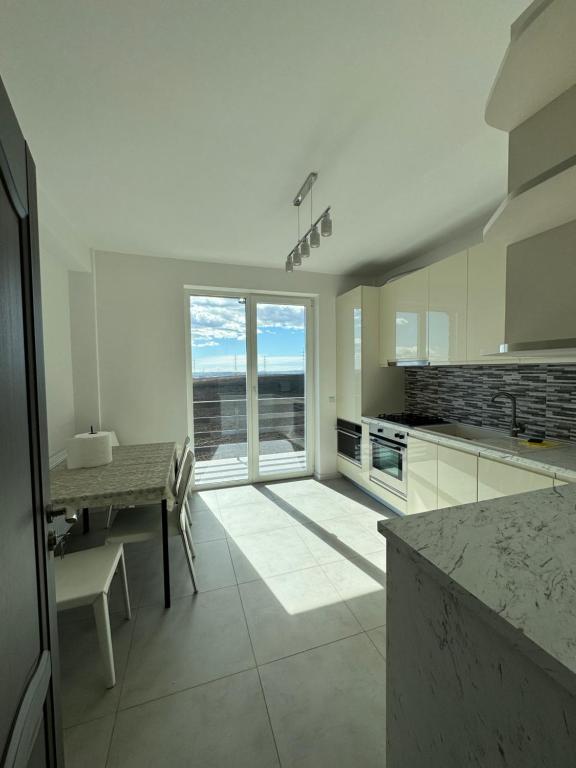 a kitchen with a table and a large window at Sunrise paradise in Suceava