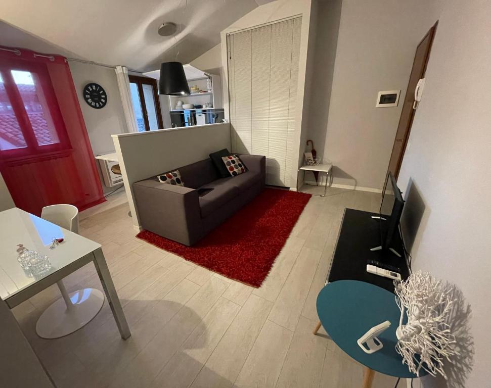 a living room with a couch and a red rug at Little Suite in Downtown Modena in Modena