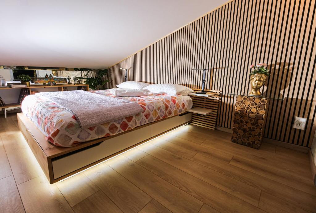 ein Schlafzimmer mit einem Bett und einer Holzwand in der Unterkunft Flytosuite Aeroporto Penthouse Attic Room in Calderara di Reno