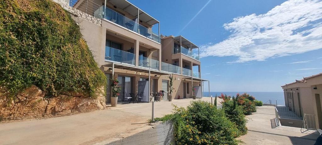 un bâtiment situé sur le côté d'une colline à côté de l'océan dans l'établissement Asteris Hotel, à Skála Kefalonias