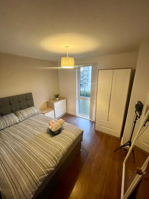 ein Schlafzimmer mit einem Bett und einem großen Fenster in der Unterkunft The Riverside in Manchester
