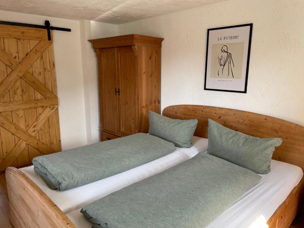 1 Schlafzimmer mit 2 Betten und einer Holztür in der Unterkunft Bohlinger Seeapartments in Bohlingen