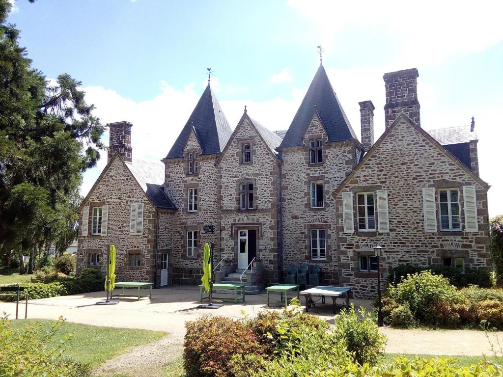 un gran edificio de ladrillo con bancos delante en Château du Bourg en Saint-Denis-de-Gastines