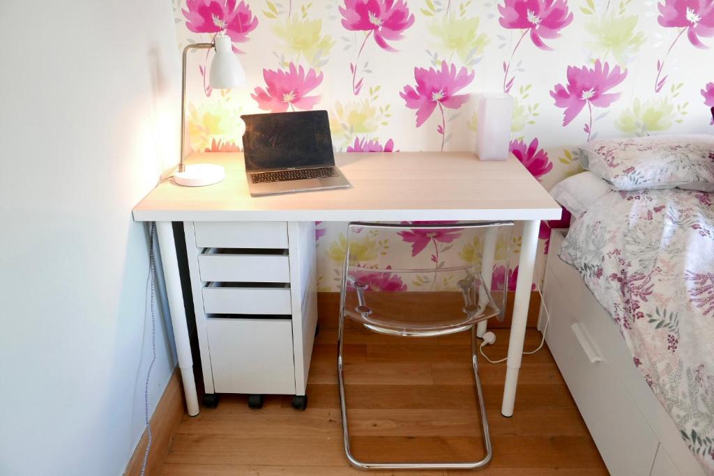 a desk with a laptop on it in a bedroom at Anna's House in Ickleford
