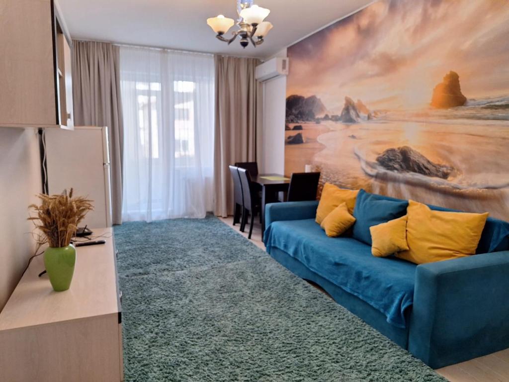 un salon avec un canapé bleu et un tableau dans l'établissement Cazare Apartament 2 camere, à Chiajna