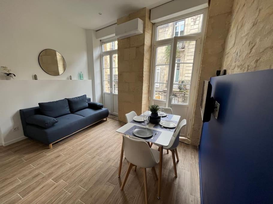 un salon avec un canapé bleu et une table dans l'établissement Appartement climatisé au cœur de Bordeaux, à Bordeaux