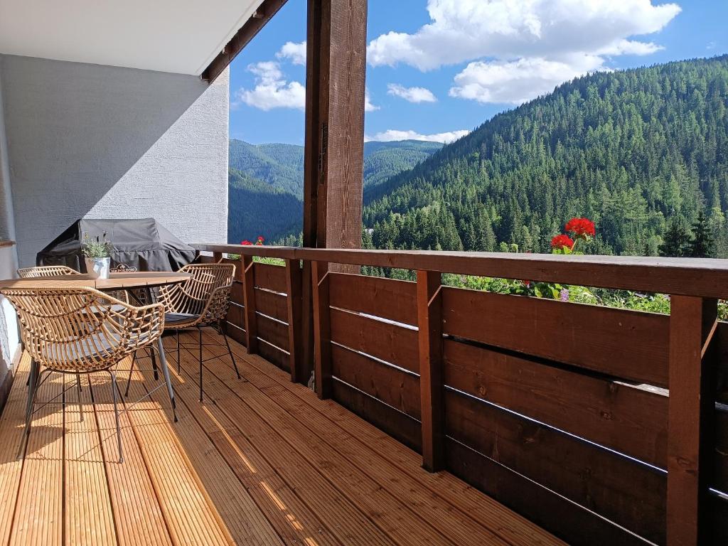 uma varanda com uma mesa e cadeiras num deque de madeira em Bergkristall Ruhe und Aussicht auf 1100m em Sankt Lorenzen ob Murau