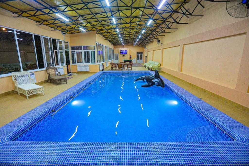 a large swimming pool in a large room at Сабзавот Давр Дача in Yalanghoch