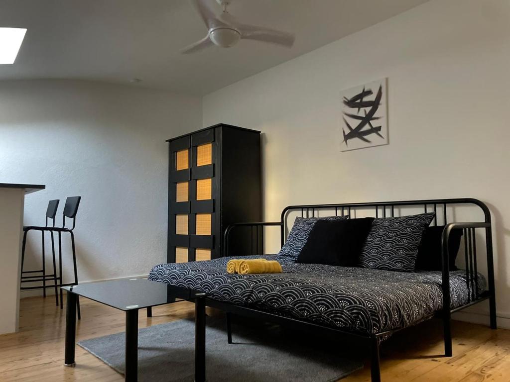 - une chambre avec un lit et une table dans l'établissement Studio sous les toits, à Nîmes