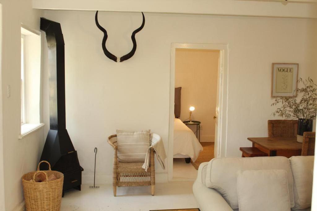 a living room with a couch and a chair at Huis Kandelabra in Oudtshoorn