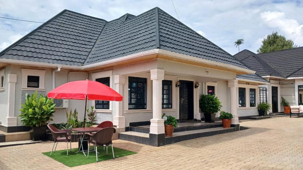 una casa con una mesa y una sombrilla roja en Cacecy Luxury Homes 2 -Bedroom, en Bungoma