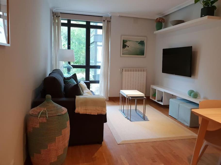 Una sala de estar con un sofá y un televisor. en Apartamento 3Banes, en Llanes