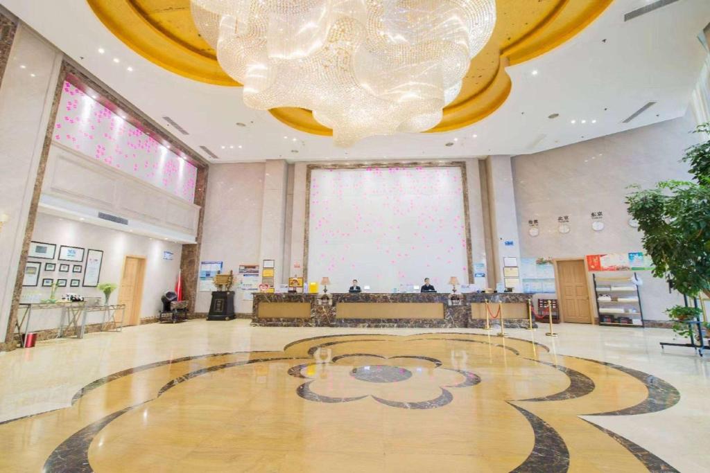 a large lobby with a large chandelier in a building at Ramada Linyi North in Linyi