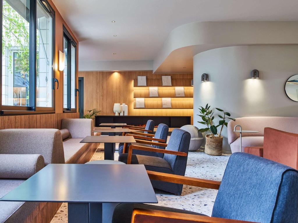 - une salle d'attente avec des tables, des chaises et des fenêtres dans l'établissement Mercure Paris 15 Porte de Versailles, à Paris