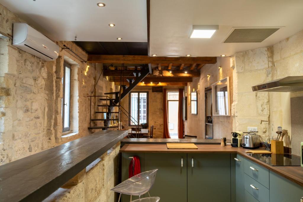 a large kitchen with a counter top and some windows at Maison de charme en centre-ville 4 à 6 personnes in Arles