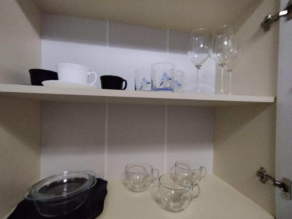 półka z kieliszkami do wina i naczyniami na niej w obiekcie Balti Apartment w mieście Bielce