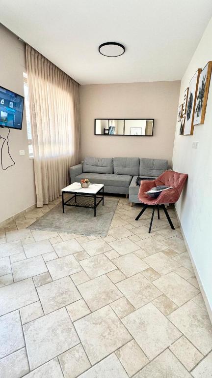 a living room with a couch and a tile floor at דירה in Jerusalem