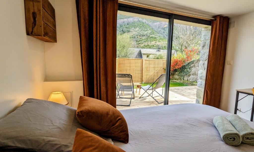 a bedroom with a bed and a large window at Le Tucou - Gîte & Spa Tout confort in Campan