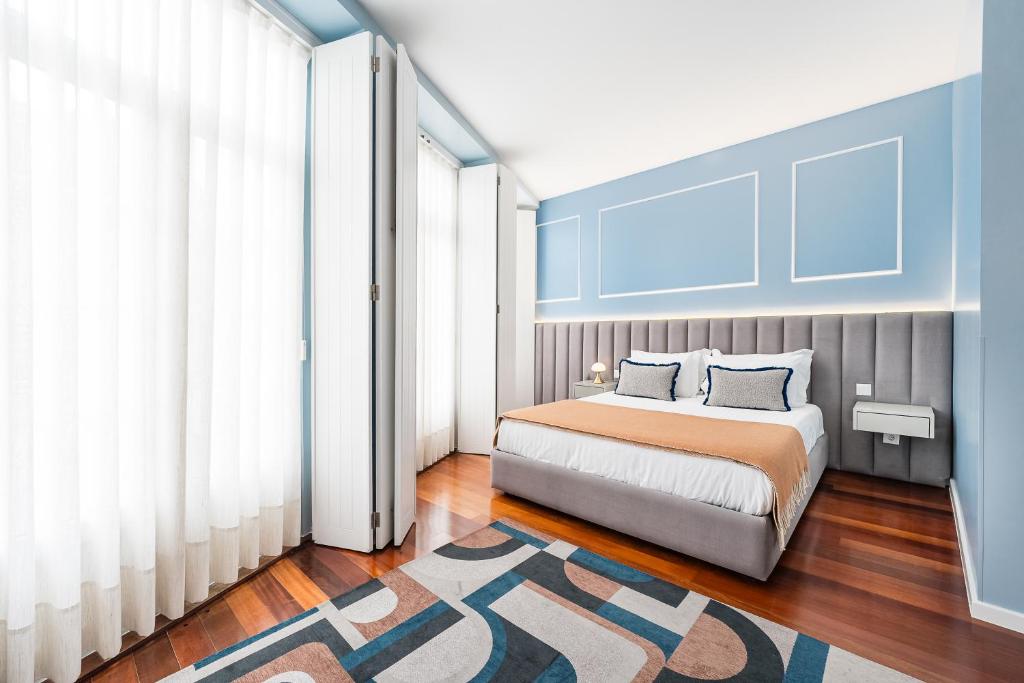 ein Schlafzimmer mit einem Bett und einer blauen Wand in der Unterkunft Victoria Project - Apartments - Private Parking in Porto