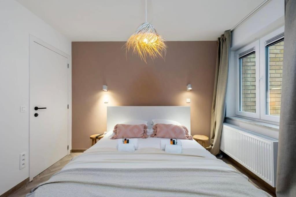 une chambre avec un grand lit avec deux oreillers dans l'établissement Raphaelle - trendy appartement met 2 slaapkamers, à Ostende