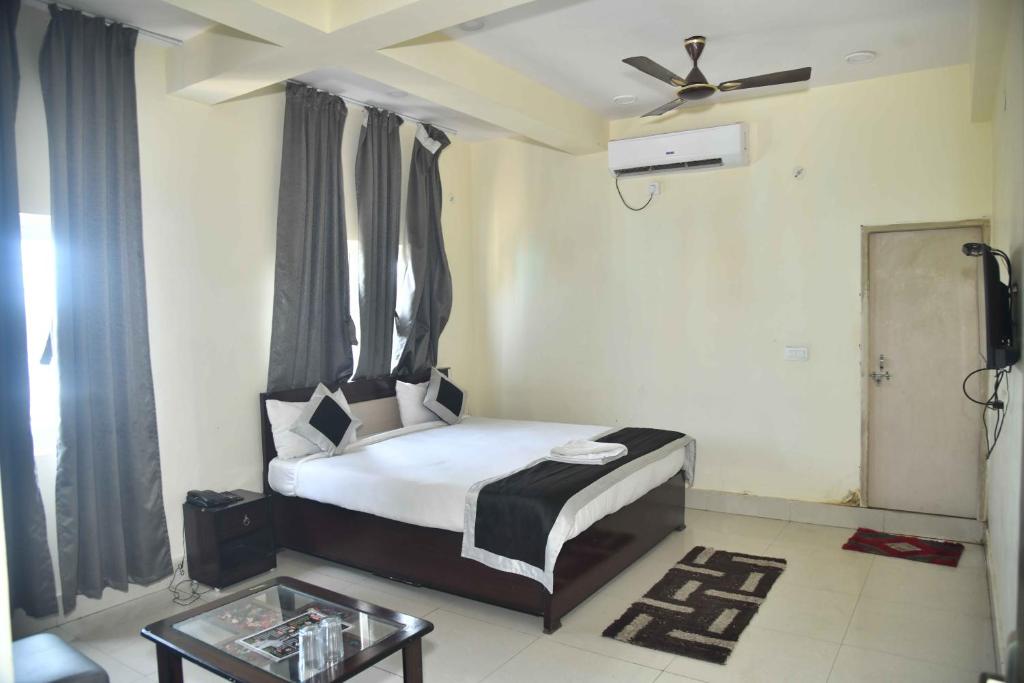 Schlafzimmer mit einem Bett und einem Deckenventilator in der Unterkunft Hotel Buddha Vibrant in Deoghar