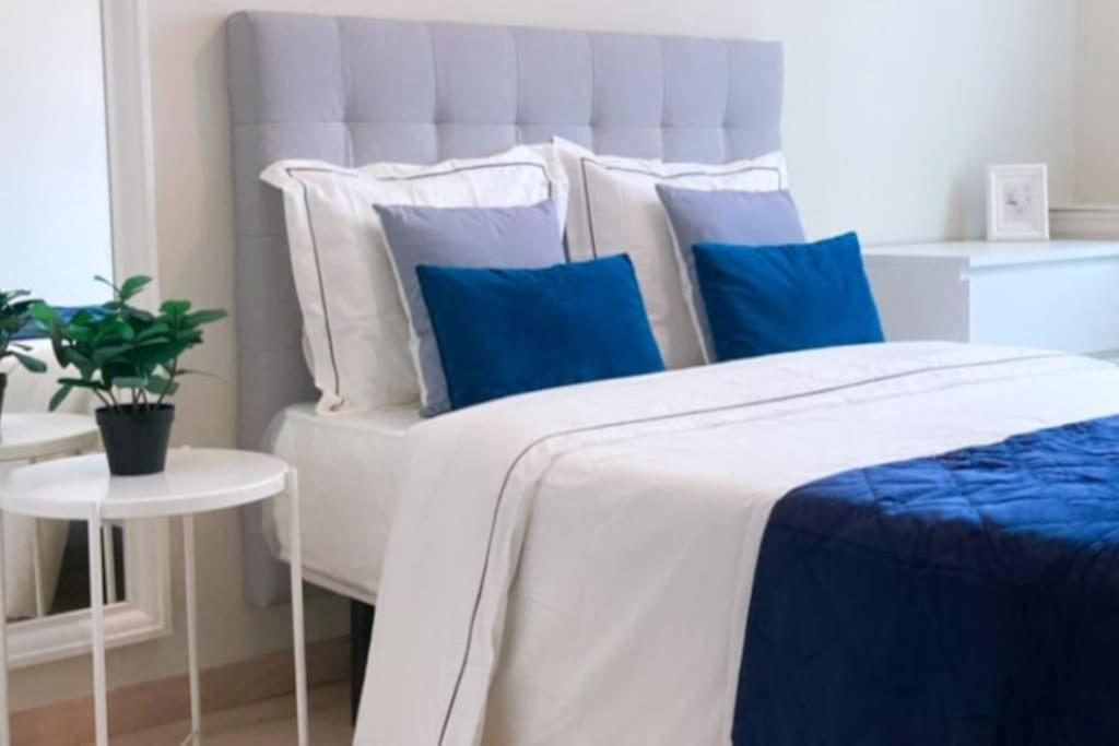 a bedroom with a bed with blue and white pillows at BilboAppartment in Bilbao