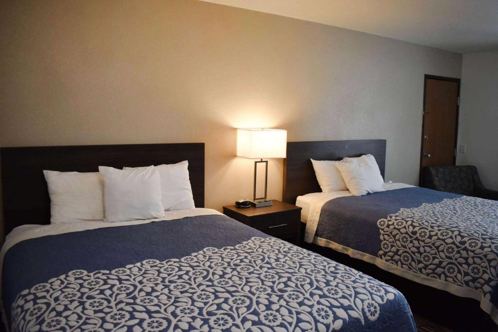 a hotel room with two beds and a lamp at Super 8 by Wyndham Grand Island in Grand Island