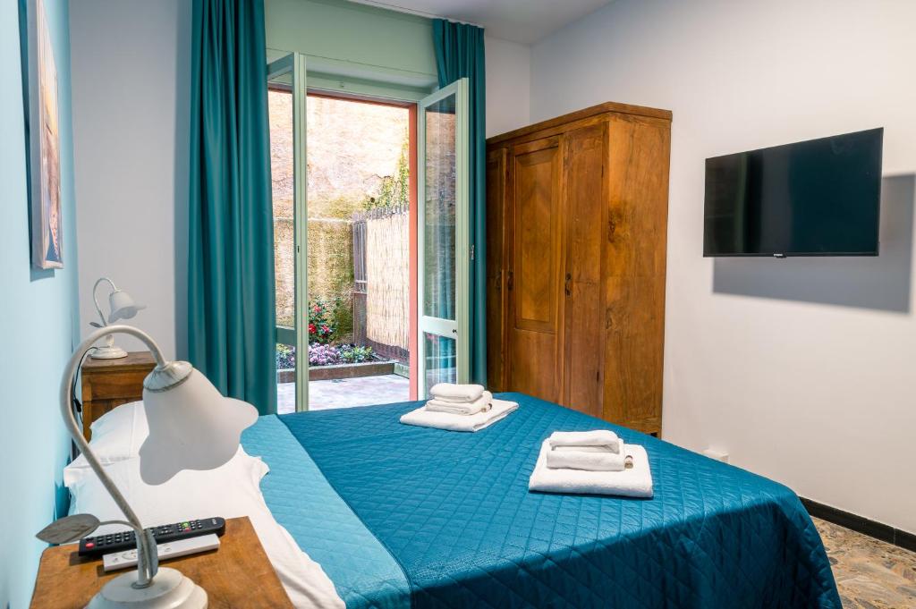 - une chambre avec un lit bleu et des serviettes dans l'établissement [Golfo Tigullio] Appartamento, à Rapallo