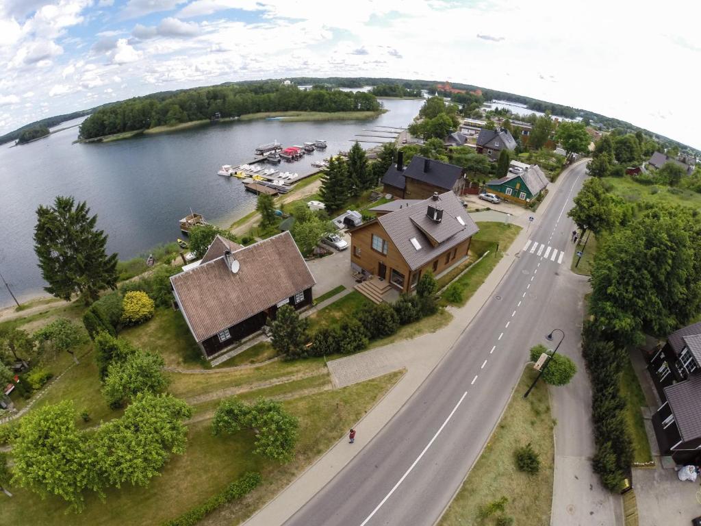 uma vista aérea de uma casa e uma estrada ao lado de um lago em Augutės Zurlienės apartamentai em Trakai