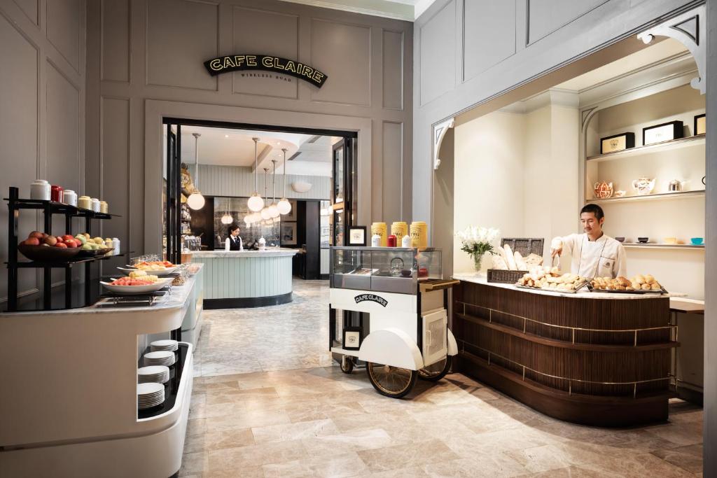 A bakery-style café display with pastries, fruit, and a staffed counter.