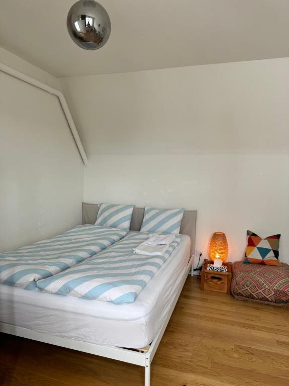 Un dormitorio con una cama y una lámpara. en City Center Studio-balcony at town hall en Basilea